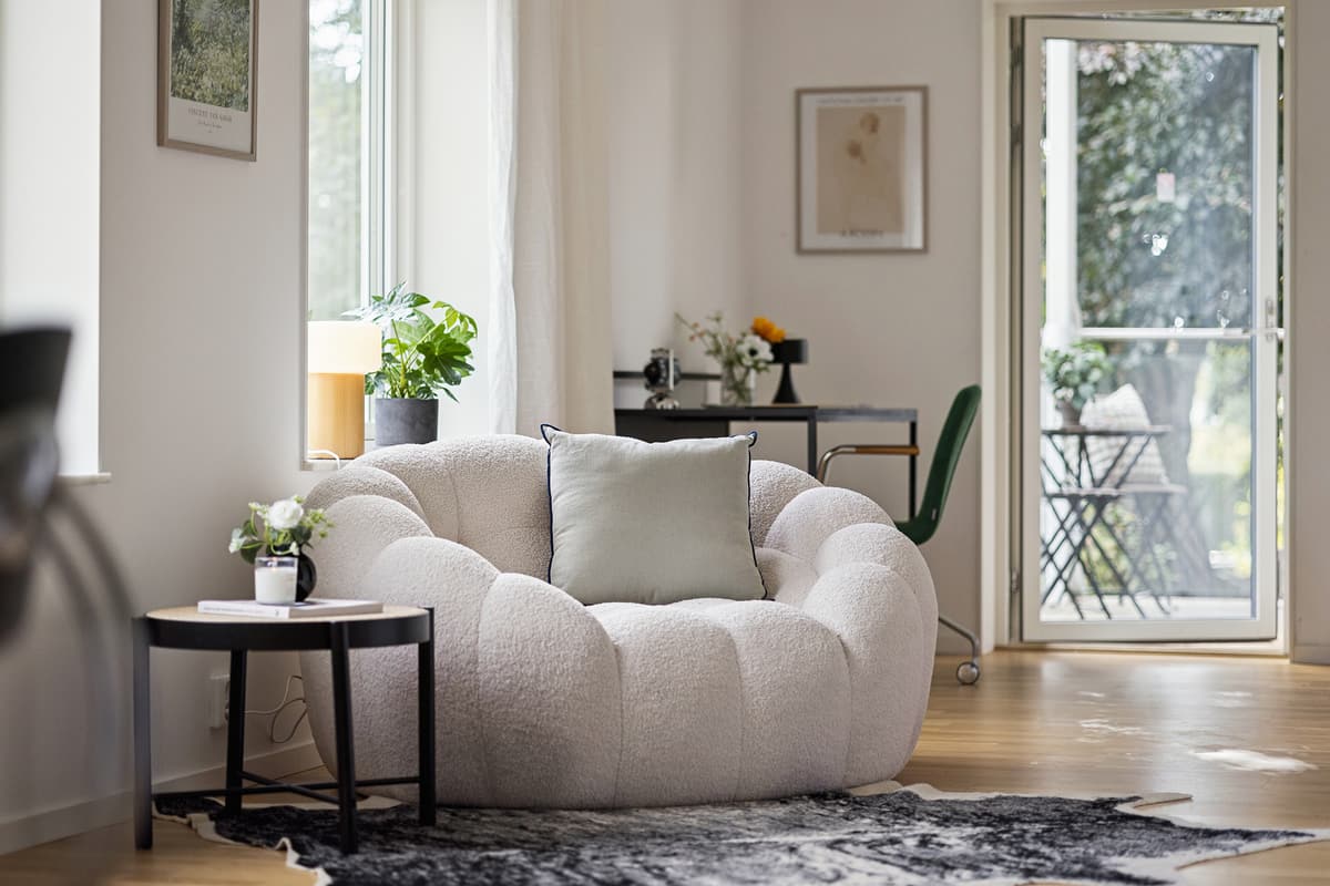 Salon z miękką sofą i wyjściem na balkon